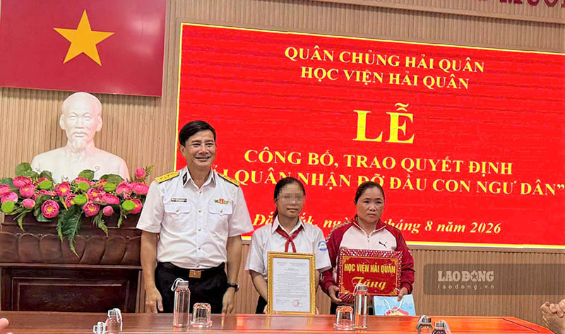 Đại tá Hồ Thanh Hòa, Phó Giám đốc Học viện Hải quân trao quyết định và tặng quà cho gia đình cháu Nguyễn Thị Tuyết Linh. Ảnh: Hải Nguyễn 
