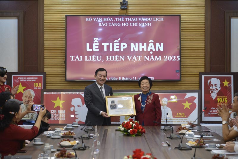 Bà Đặng Minh Châu thay mặt gia đình hiến tặng những bức ảnh quý chụp cùng Bác Hồ cho Bảo tàng Hồ Chí Minh. Ảnh: Bảo tàng Hồ Chí Minh