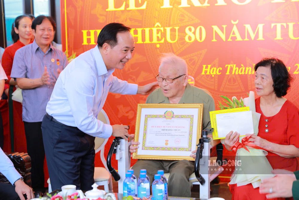 Trưởng Ban Tuyên giáo Trung ương Trịnh Văn Quyết trao Huy hiệu 80 năm tuổi Đảng cho ông Trịnh Khắc Thuần. Ảnh: Minh Hoàng