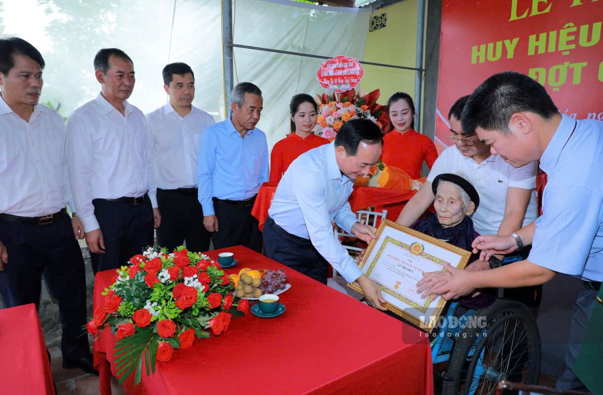 Politburo Member, Secretary of the Party Central Committee, Head of the Central Propaganda and Training Commission Trinh Van Quyet awarded the 80-year Party Badge to Ms. Le Thi Thuy. Photo: Minh Hoang