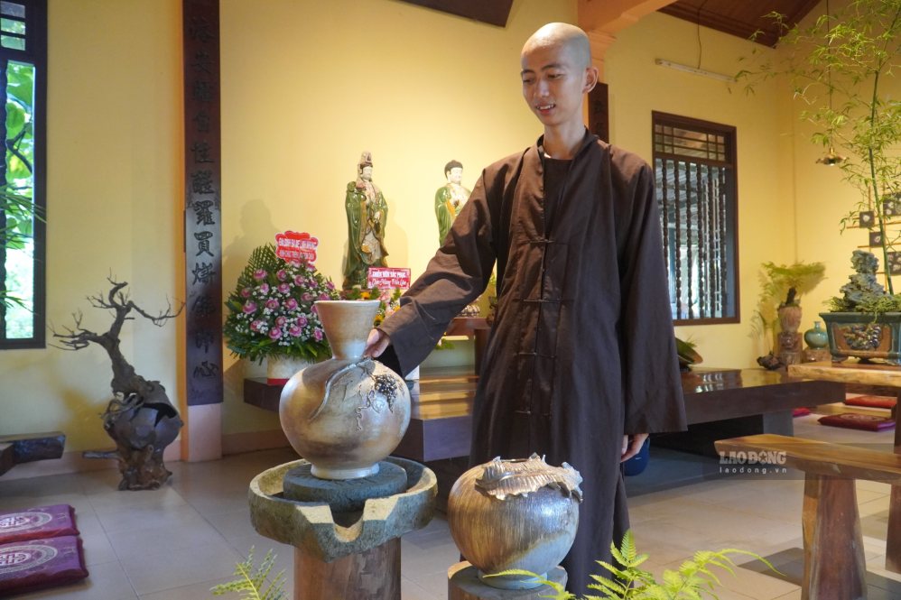 Venerable Thich Dao Nguyen next to unique wood-fired ceramic works at the 2026 Pagoda Pottery Exhibition. Photo: HAC