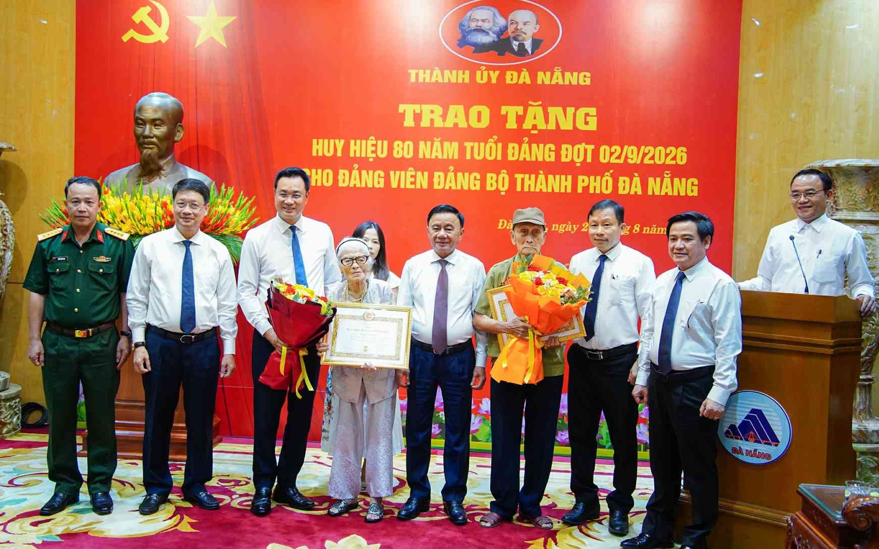 Politburo Member, Standing Secretary of the Secretariat Tran Cam Tu and Member of the Party Central Committee, Secretary of the City Party Committee Le Ngoc Quang awarded the 80-year Party Badge, presented flowers and congratulated party members. Photo: Mai Quang (Da Nang City People's Committee)