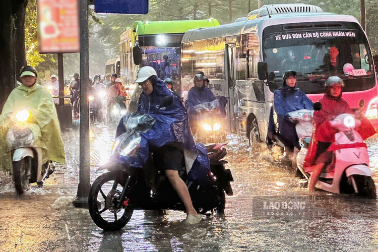 Một số xe máy phải đi lên vỉa hè để tránh ngập sâu. Ảnh: Tô Thế