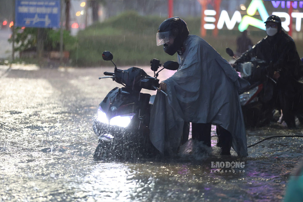 深い浸水により、一部の車両がエンストし、住民は浸水区間を押して通過しなければなりませんでした。写真:ズオン・アイン