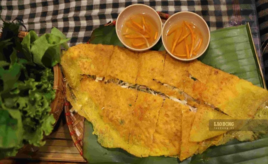 Du khách quốc tế trải nghiệm suất bánh xèo được cắt thành từng miếng vừa ăn, dùng kèm rau sống và nước mắm chua ngọt theo phong cách miền Tây Nam Bộ. Ảnh: Minh Vũ