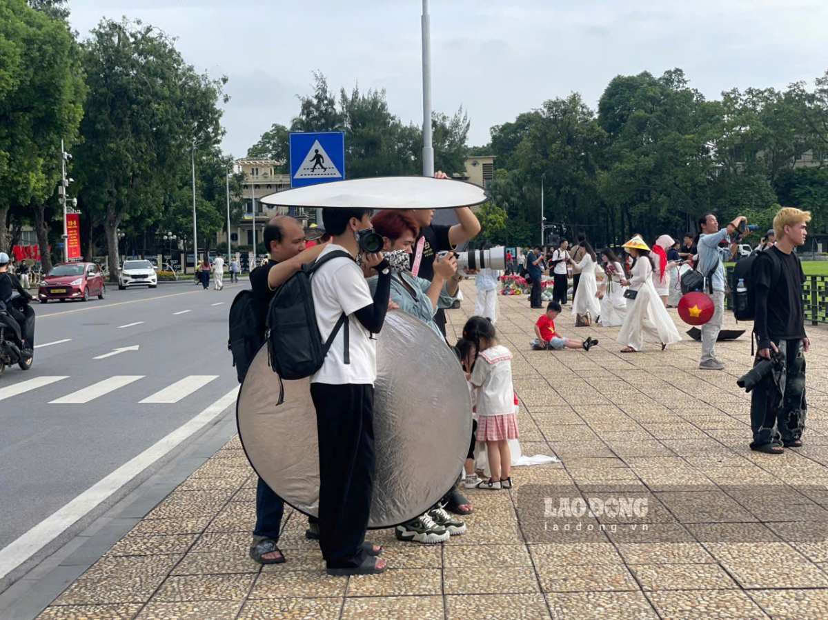 Do trời nắng gắt, các thợ ảnh phải dùng tấm hắt sáng làm mái che tạm để tránh nắng trong lúc tác nghiệp. Ảnh: I La
