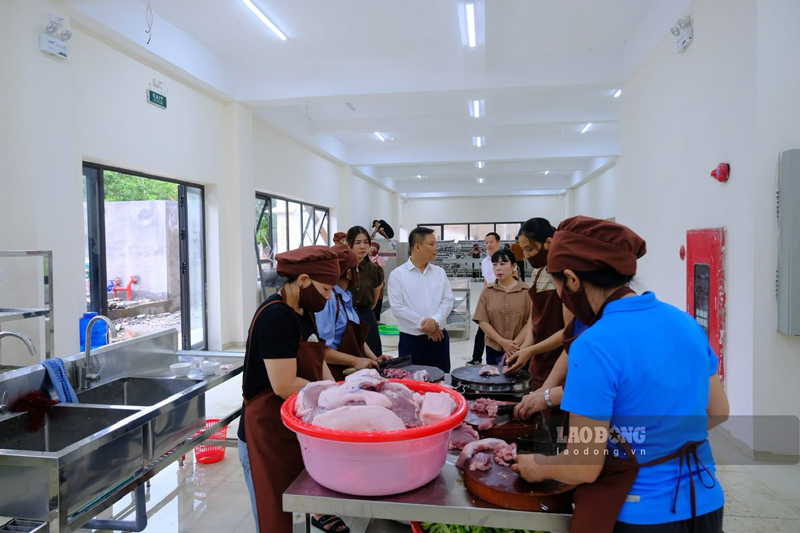 Nhân viên nhà bếp chuẩn bị thức ăn phục vụ học sinh trong ngày đầu các em chuyển về trường. Ảnh: Đinh Đại