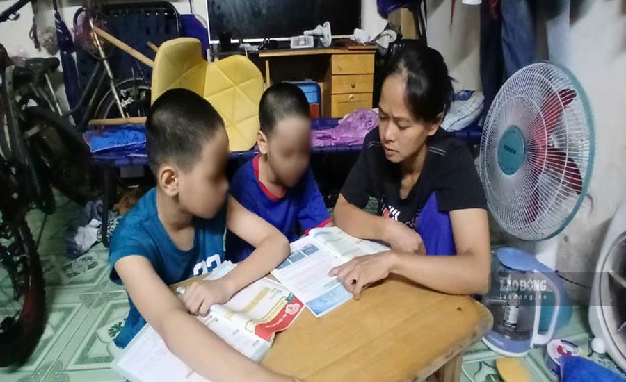 Ms. Nguyen Ngoc Hoang takes advantage of free time to teach her two young children to study. Photo: Minh Tam