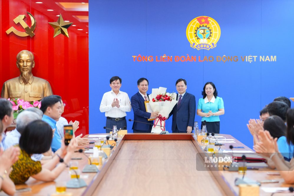 Đại diện lãnh đạo Tổng LĐLĐVN tặng hoa chúc mừng ông Vũ Anh Đức (thứ 2 từ trái sang). Ảnh: Hữu Chánh