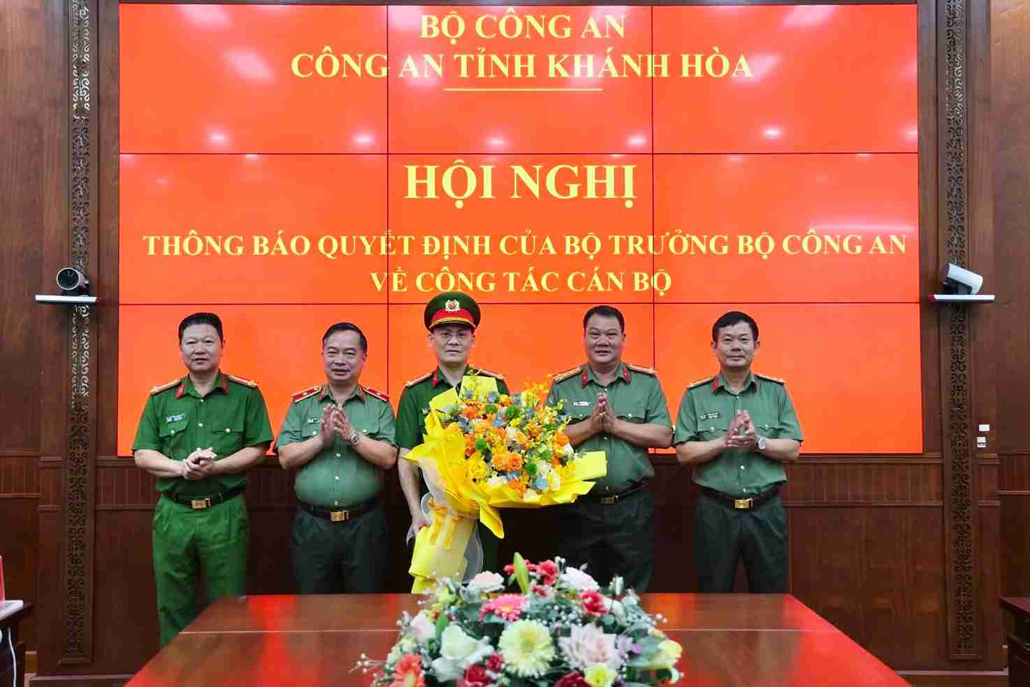 Leaders of Khanh Hoa Provincial Police present flowers to congratulate Colonel Nguyen Ba Thanh (middle) on receiving his new assignment. Photo: Khanh Hoa Provincial Police
