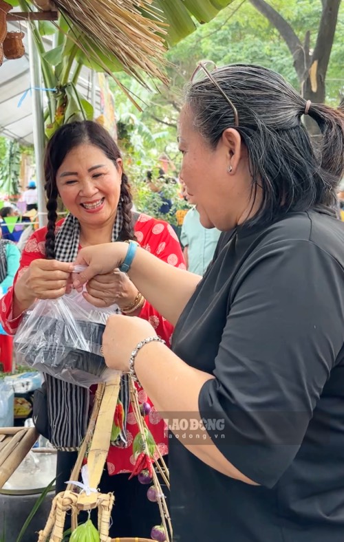 Bà Trần Bạch Ngọc (bên trái) vui vẻ khi được nhiều khách hàng ủng hộ gian bán bánh truyền thống. Ảnh: Mai Anh. 