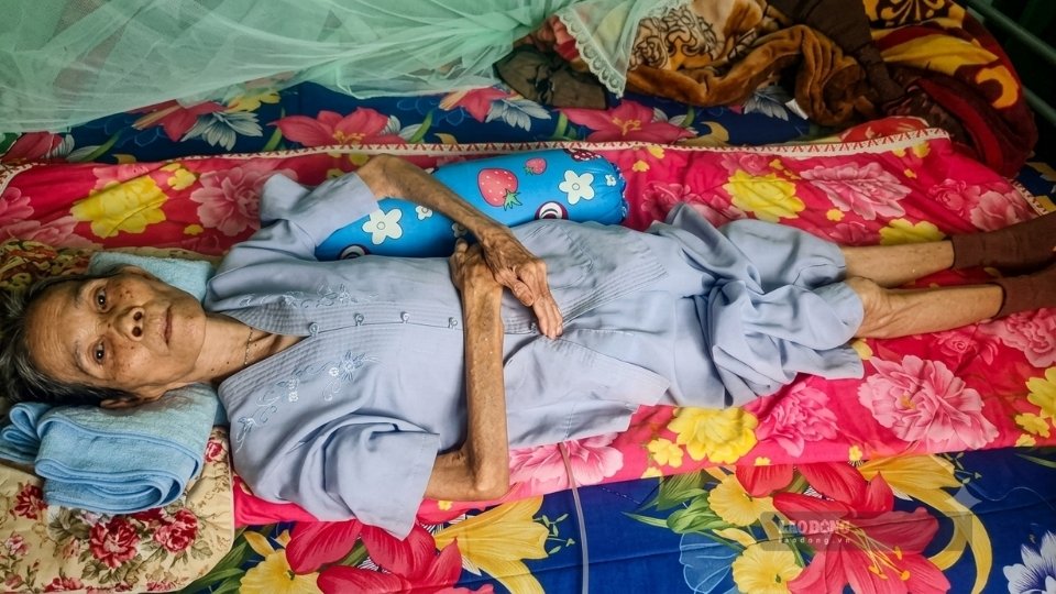 Ms. Ho Thi Ly is lying in one place in a dilapidated house, next to her are the medicines she is using every day. Photo: Hoang Loc