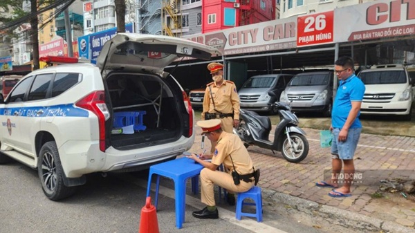 Lực lượng CSGT Công an TP Hà Nội xử lý phương tiện đón trả khách không đúng nơi quy định trên đường Phạm Hùng. Ảnh: Minh Hạnh