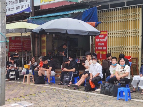 Trong khi các bến xe vắng khách, thì nhiều hành khách vẫn ngồi ngoài bến chờ đón xe. Ảnh: Minh Hạnh
