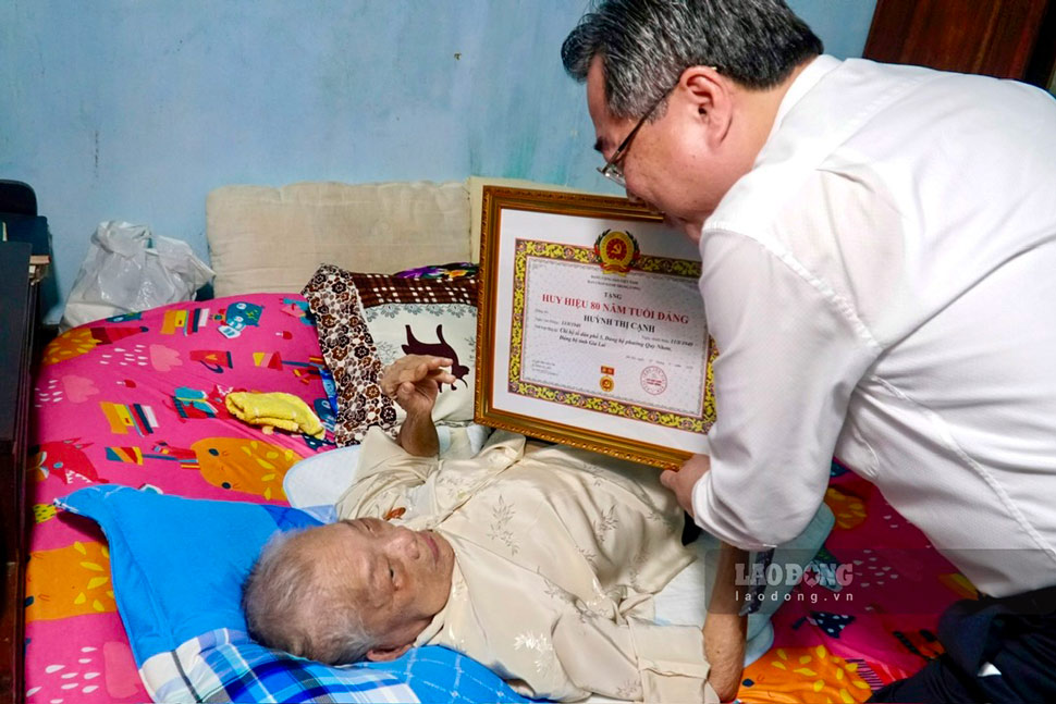 Mr. Nguyen Thanh Nghi - Member of the Politburo, Secretary of the Party Central Committee, Head of the Central Policy and Strategy Committee - awarded the 80-year Party Badge to Ms. Huynh Thi Canh, party member of Party Cell of Residential Group 5, Party Committee of Quy Nhon Ward, Gia Lai. Photo: Thu Loan