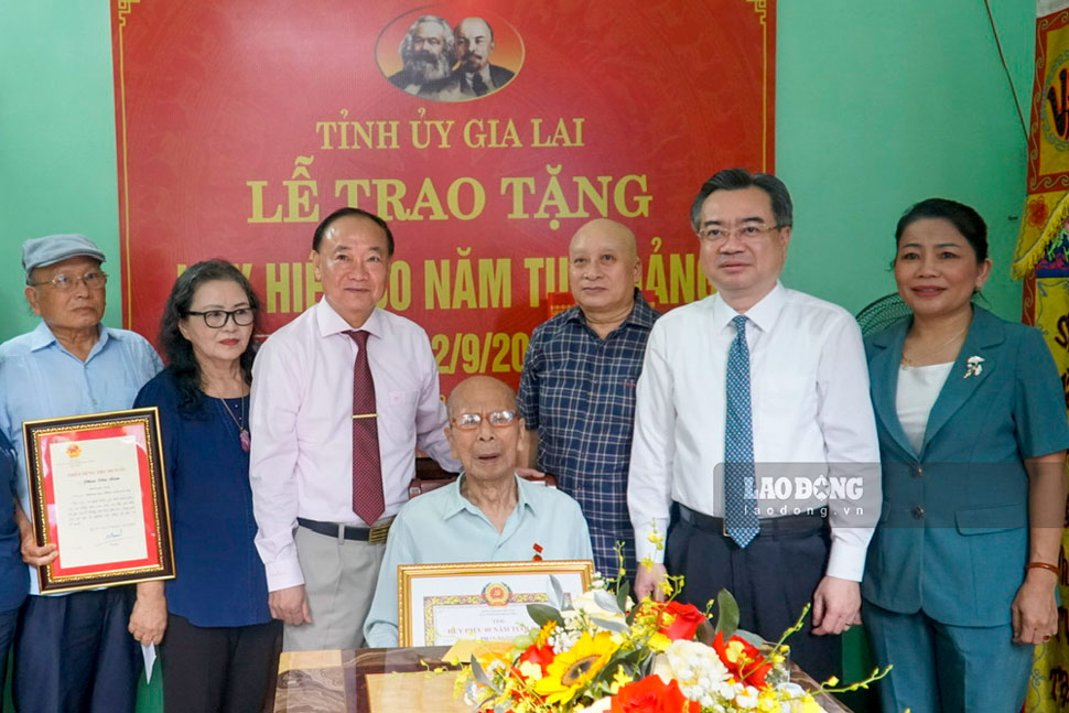 Ông Nguyễn Thanh Nghị - Ủy viên Bộ Chính trị, Bí thư Trung ương Đảng, Trưởng ban Chính sách, chiến lược Trung ương - trao Huy hiệu 80 tuổi Đảng cho đảng viên Phan Ngọc Bích. Ảnh: Thu Loan