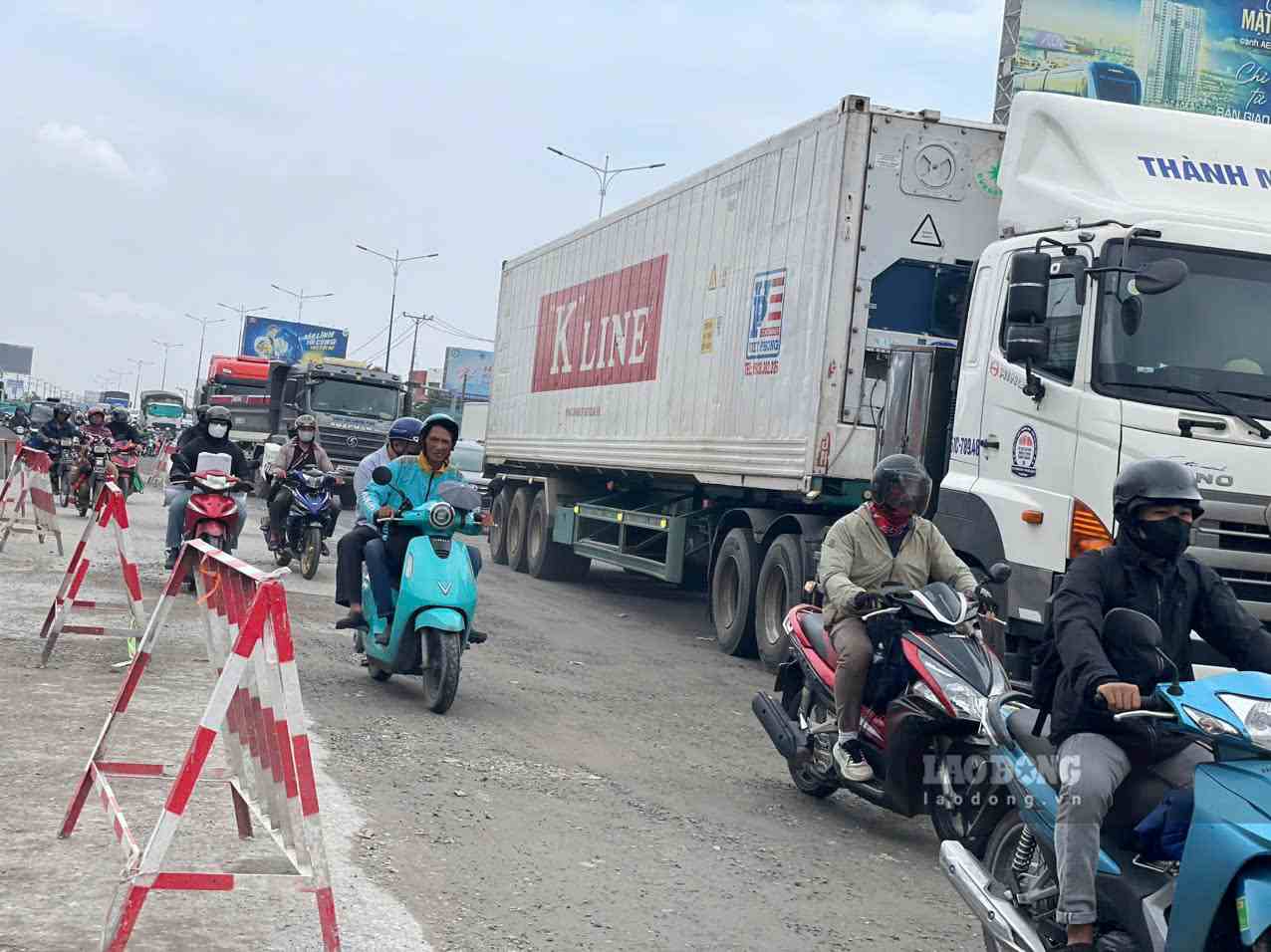 Phương tiện vất vả lưu thông qua đoạn đang thi công mở rộng Quốc lộ 13. Ảnh: Đình Trọng