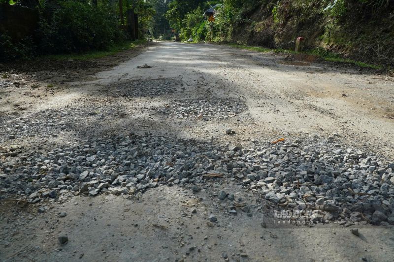 Mặt đường trên tuyến tỉnh lộ bị bong tróc, với đất đá lởm chởm. Ảnh: Quách Du