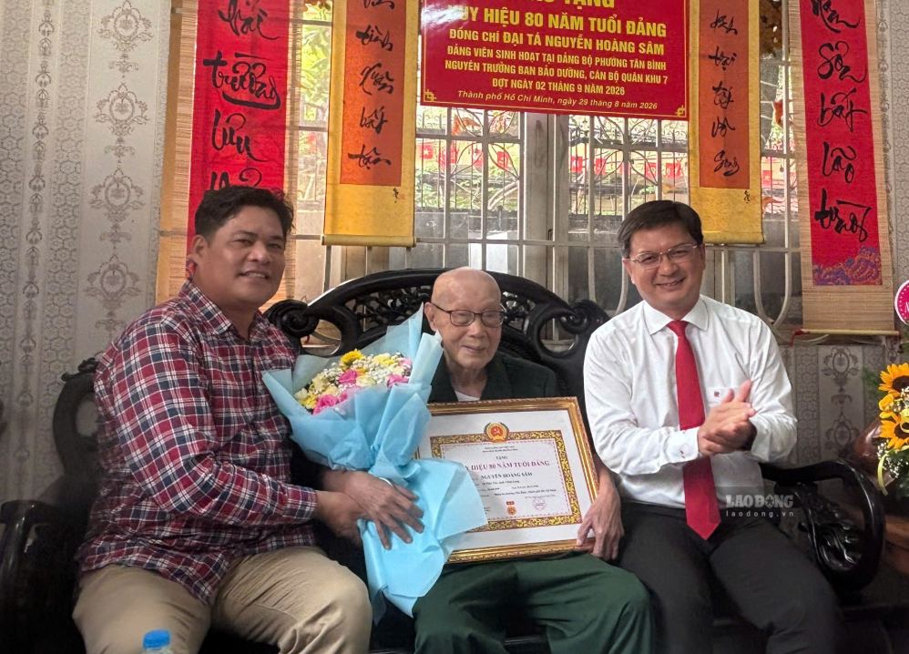Mr. Nguyen Hoang Sam excitedly receives the 80-year Party Badge. Photo: Minh Tam