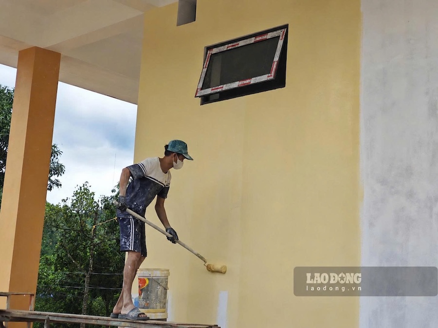 Công nhân quét sơn một khối nhà ở trường nội trú liên cấp. Ảnh: Hàn Nguyên