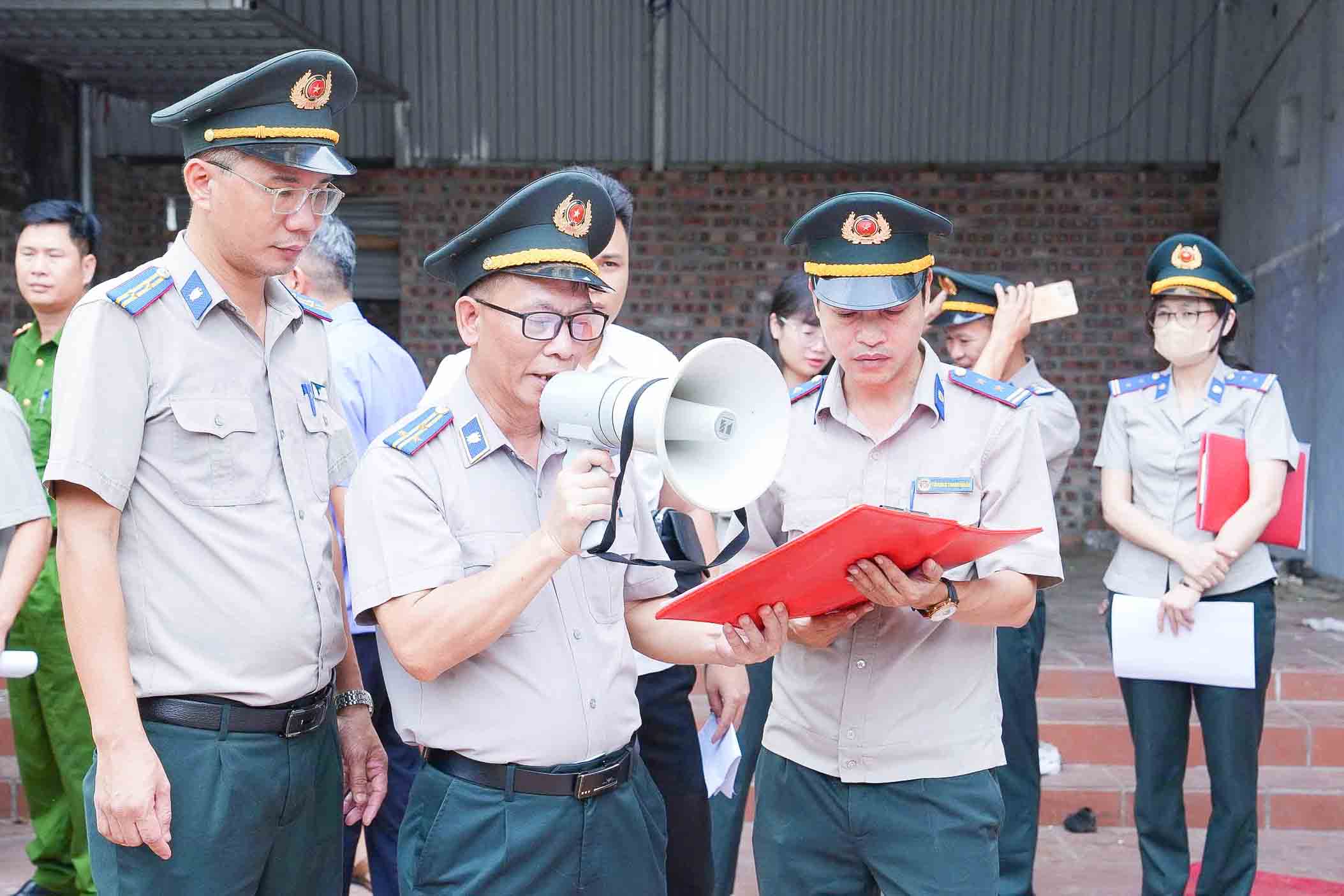 Functional forces read the decision to enforce the civil judgment against Mr. L.D. H and Ms. D.T.H. Photo: Quoc Oai Commune e-information page