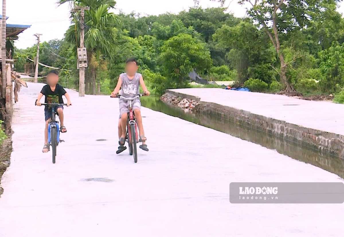 Young children excitedly walk on the new village road. Photo: Ha Vi