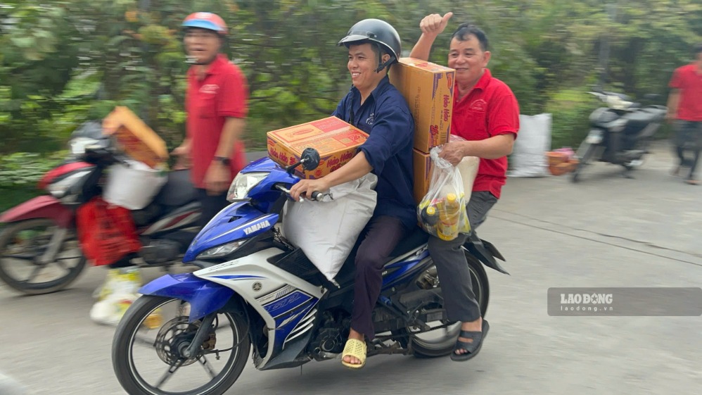 Workers excitedly carry gifts for the September 2nd holiday home. Photo: Minh Tam