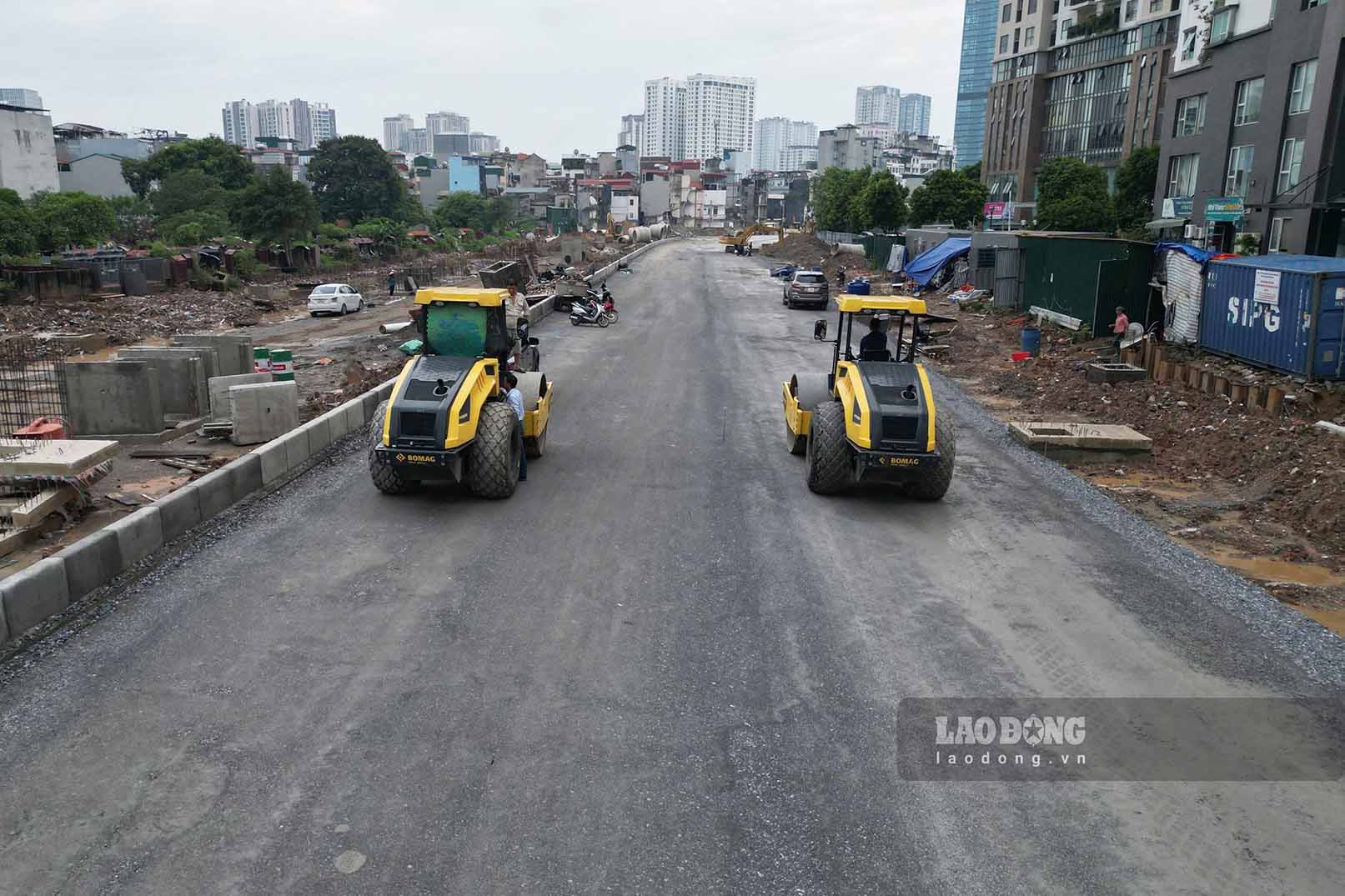 Workers compact the surface of Ring Road 2.5 section passing through Cau Giay. Photo: Huu Vu