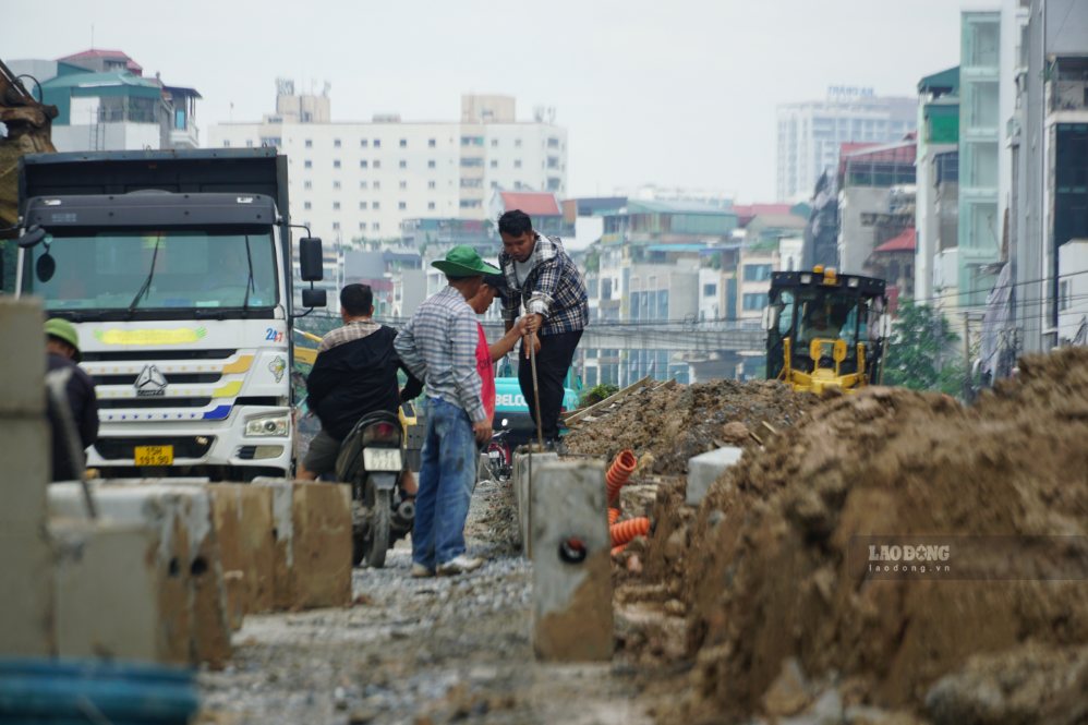 Công nhân lắp đặt bó vỉa dọc tuyến Vành đai 2,5 đoạn qua Cầu Giấy. Ảnh: Hữu Vũ
