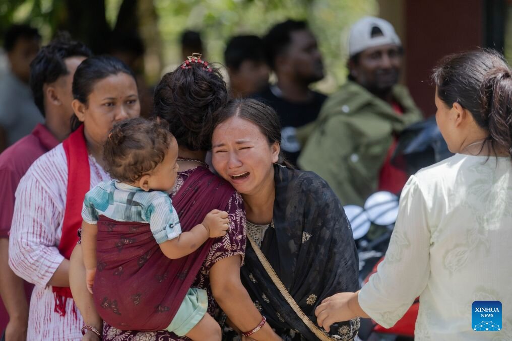 Gente esperando noticias sobre familiares desaparecidos tras las inundaciones repentinas en Nuwakot, Nepal, el 27 de agosto de 2026. Foto: Xinhua