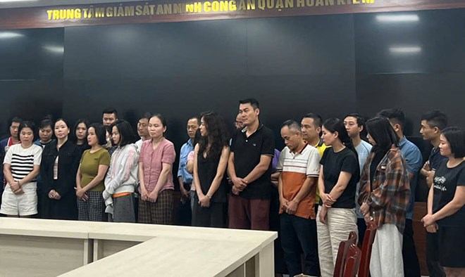 Bị can Nguyễn Thị Mai Anh (áo đen, hàng đầu, thứ hai từ trái qua) nhiều lần nhận tiền chạy bệnh án tâm thần. Ảnh: Công an TP Hà Nội