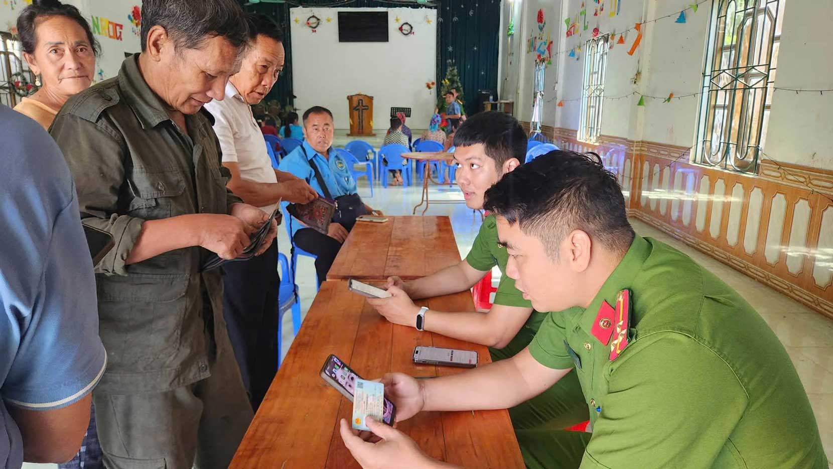 Commune police officers guide people to integrate health insurance cards on the VNeID application. Photo: Xuan Quang Commune Police