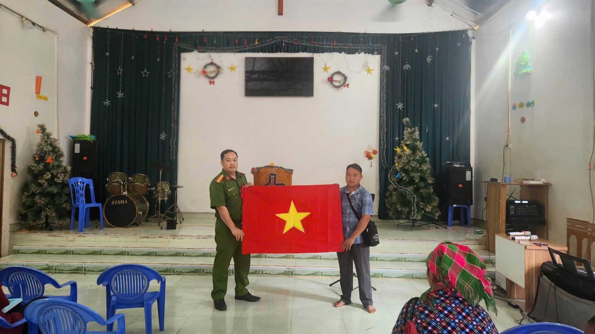 Công an xã trao cờ Tổ quốc cho người dân. Ảnh: Công an xã Xuân Quang
