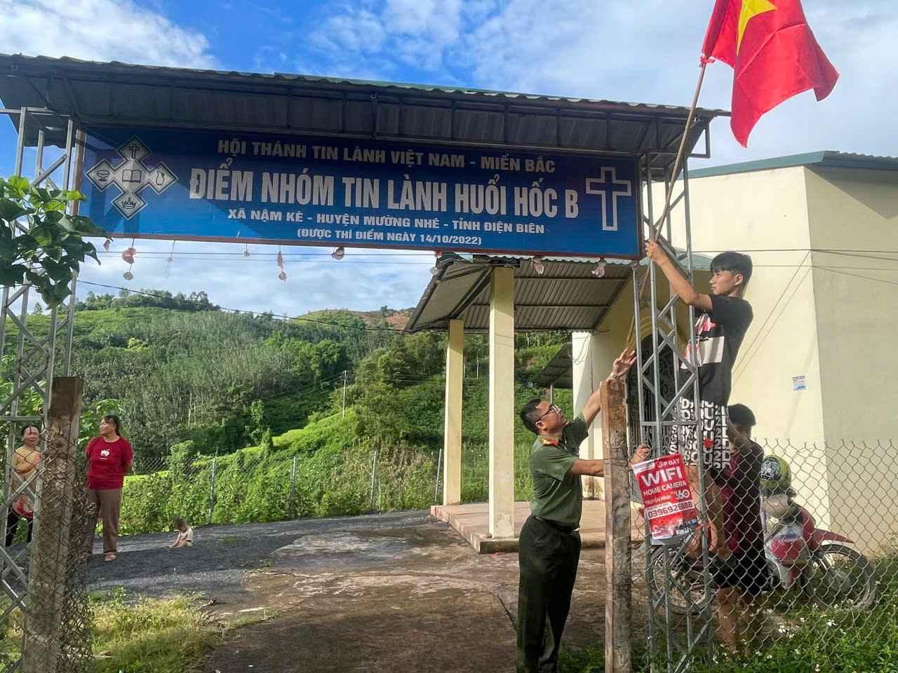 Tặng cờ cho Nhân dân điểm sinh hoạt tôn giáo Huổi Hốc B. Ảnh: Công an Điện Biên