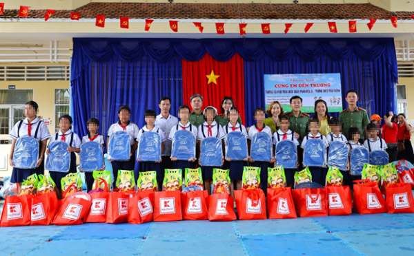 Phòng Tham mưu Công an tỉnh Cà Mau cùng đại diện các đơn vị tài trợ tặng quà cho các em học sinh tại Chương trình “Cùng em đến trường”. Ảnh: Cổng TTĐT Công an tỉnh Cà Mau