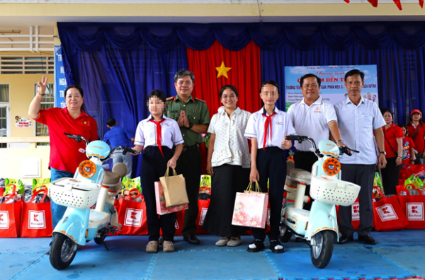 Lieutenant Colonel Le Ngoc Linh, Deputy Head of the Department, Staff Department of Ca Mau Provincial Police, and sponsors donated electric bicycles to 2 students of Tran Huynh Secondary School. Photo: Ca Mau Provincial Police e-Portal