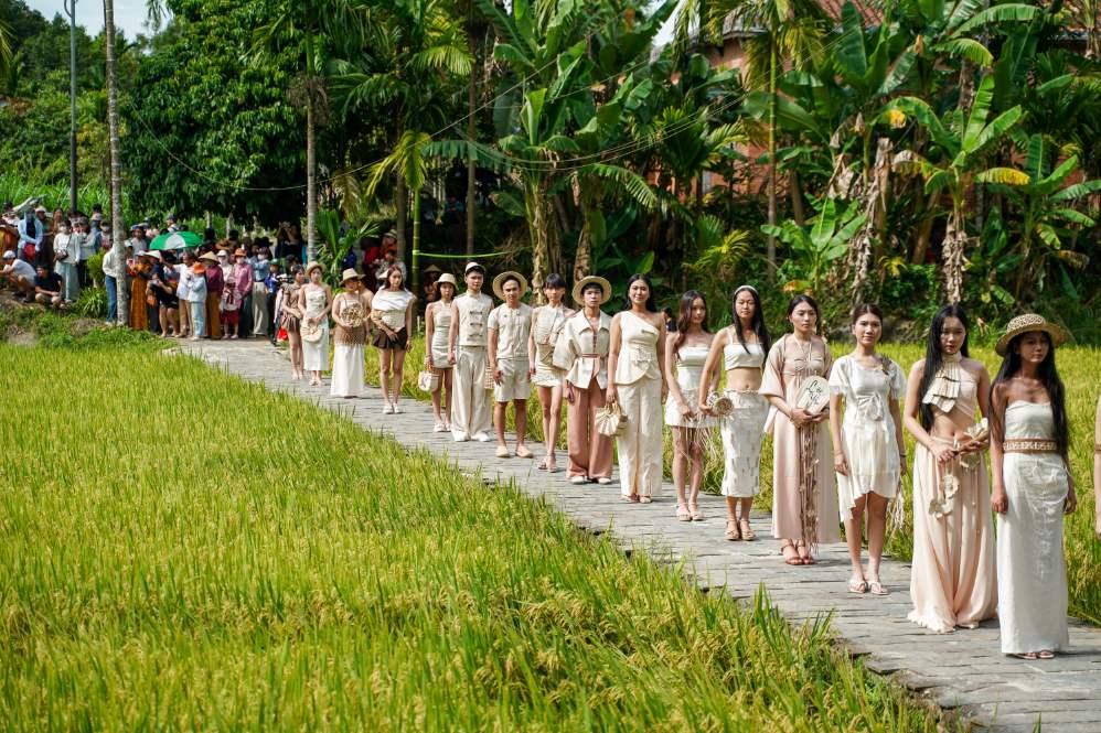 Sàn diễn uốn lượn giữa cánh đồng lúa chín tại Làng cổ Lộc Yên. Ảnh: DTU