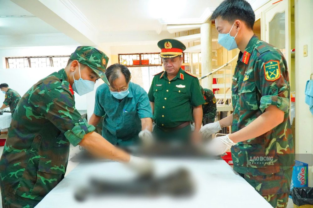 Bác sĩ Trần Văn Bản (thứ hai từ trái qua) tỉ mỉ thực hiện công việc tại khu vực lấy mẫu và lưu mẫu hài cốt liệt sĩ. Ảnh: Anh Tú