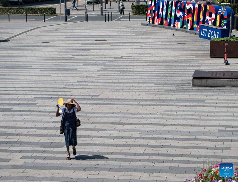 2026年6月24日、ドイツのデュイスブルクで暑い日差しの中を歩く女性。写真:新華社