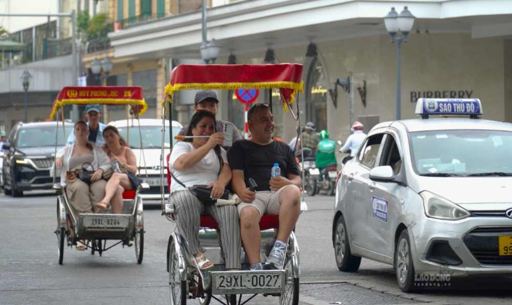 European tourists sit in a cyclo exploring Hanoi. Photo: Minh Chinh