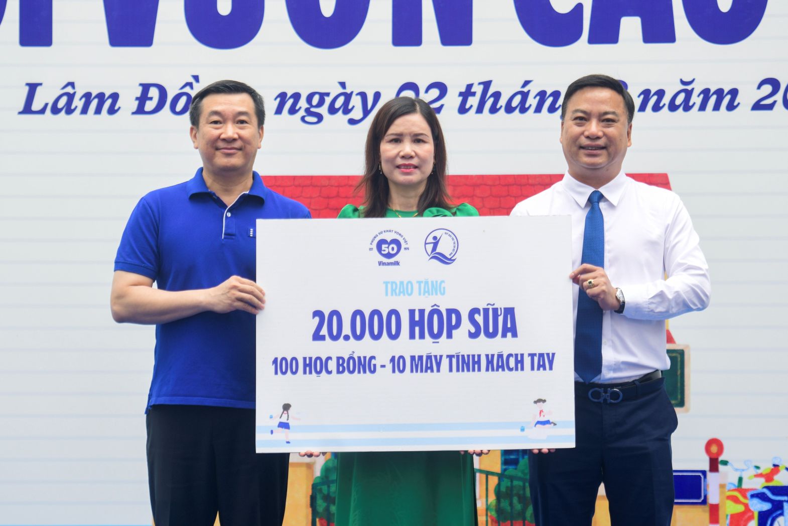 Đại diện Quỹ sữa Vươn cao Việt Nam, ông Đỗ Thanh Tuấn - Giám đốc Đối ngoại Vinamilk (bên trái) và ông Đinh Tiến Hải - Giám đốc Quỹ Bảo trợ Trẻ em Việt Nam - trao bảng tượng trưng các phần quà thiết thực cho đại diện Trường Tiểu học An Hiệp, xã Hiệp Thạnh. Ảnh: Hải An 