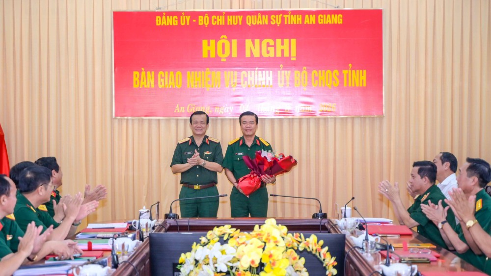 Trung tướng Hồ Văn Thái, Bí thư Đảng ủy - Chính ủy Quân khu 9 trao hoa chúc mừng Đại tá Nguyễn Việt Thắng – Phó Bí thư Thường trực Đảng ủy Quân sự, Chính ủy Bộ CHQS tỉnh. Ảnh: Phương Vũ/Bộ CHQS An Giang