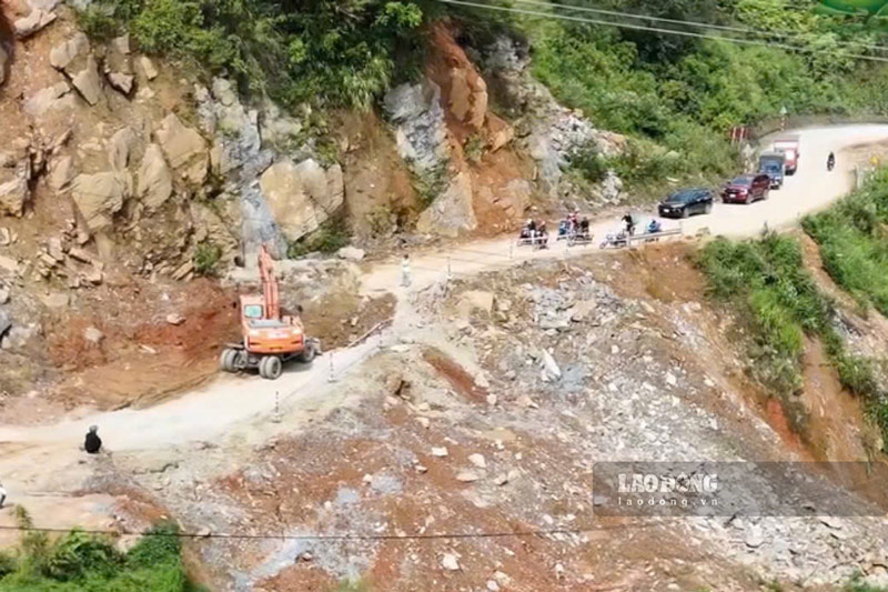 Người dân điều khiển phương tiện di chuyển chậm qua điểm sạt lở trên Quốc lộ 4E đoạn qua xã Lùng Phình. Ảnh: Đinh Đại