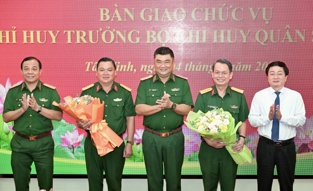Leaders of Military Region 7 and Tay Ninh Provincial Party Committee present flowers to congratulate 2 military officers who have just received new assignments. Photo: quansu. tayninh. gov. vn