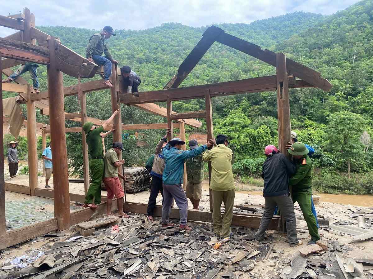 Officers and soldiers of Muong Tip Commune Police and people of Xop Phe village dismantle houses, supporting households to relocate to resettlement areas. Photo: Nghe An Police