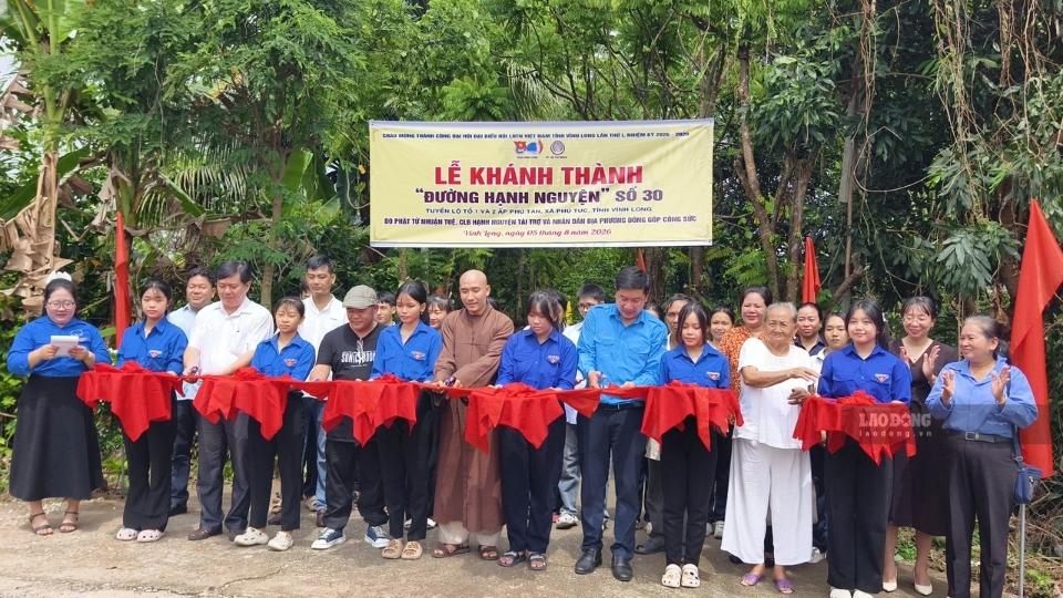 Delegates perform the ribbon-cutting ceremony to inaugurate "Happiness Road" No. 30. Photo: Hoang Loc