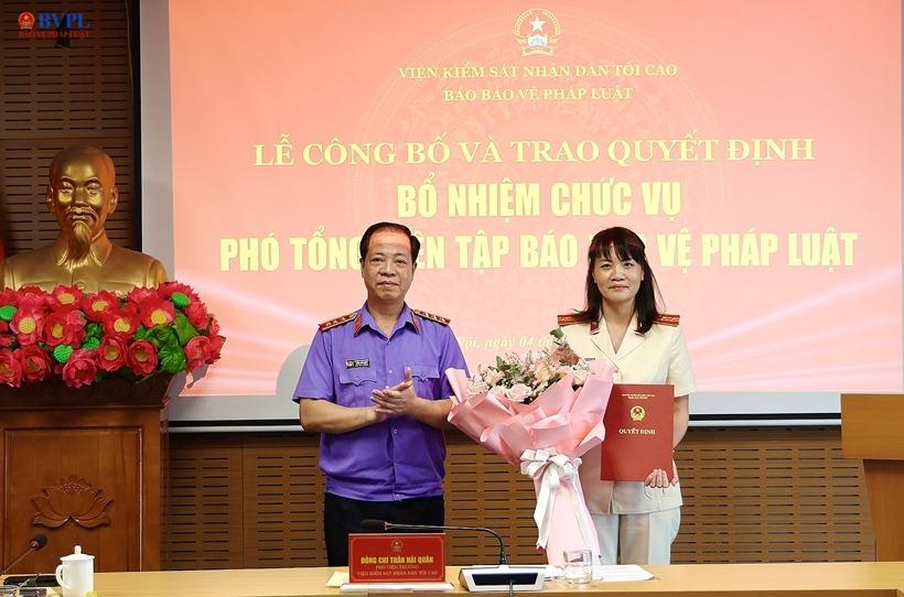 Ông Trần Hải Quân - Phó Viện trưởng VKSND tối cao trao quyết định và tặng hoa chúc mừng bà Hồ Thị Kim Thoan được bổ nhiệm giữ chức vụ Phó Tổng Biên tập Báo BVPL. Ảnh: Báo Bảo vệ pháp luật