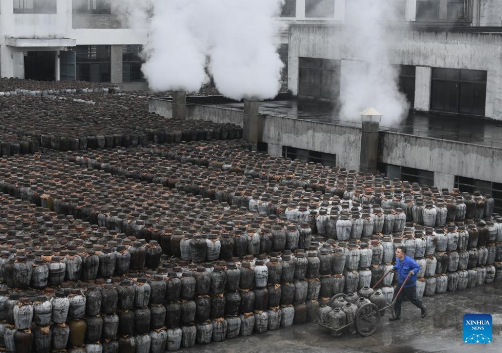 Một công nhân vận chuyển các bình rượu vang tại một nhà máy rượu gạo ở quận Nhạc Thành của Thiệu Hưng. Ảnh: Xinhua