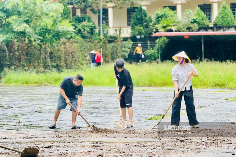 Lực lượng chức năng và người dân xã Cốc San dọn dẹp bùn đất, khắc phục hậu quả sau mưa lũ. Ảnh: Vân Anh