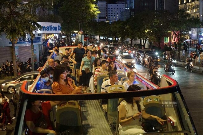 Du khách khám phá TPHCM về đêm trên xe buýt 2 tầng. Ảnh: Thanh Chân